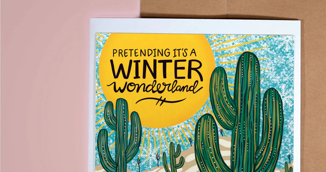 Card with cactus illustration and 'Pretending it's a Winter Wonderland' text, brown envelope on pink background